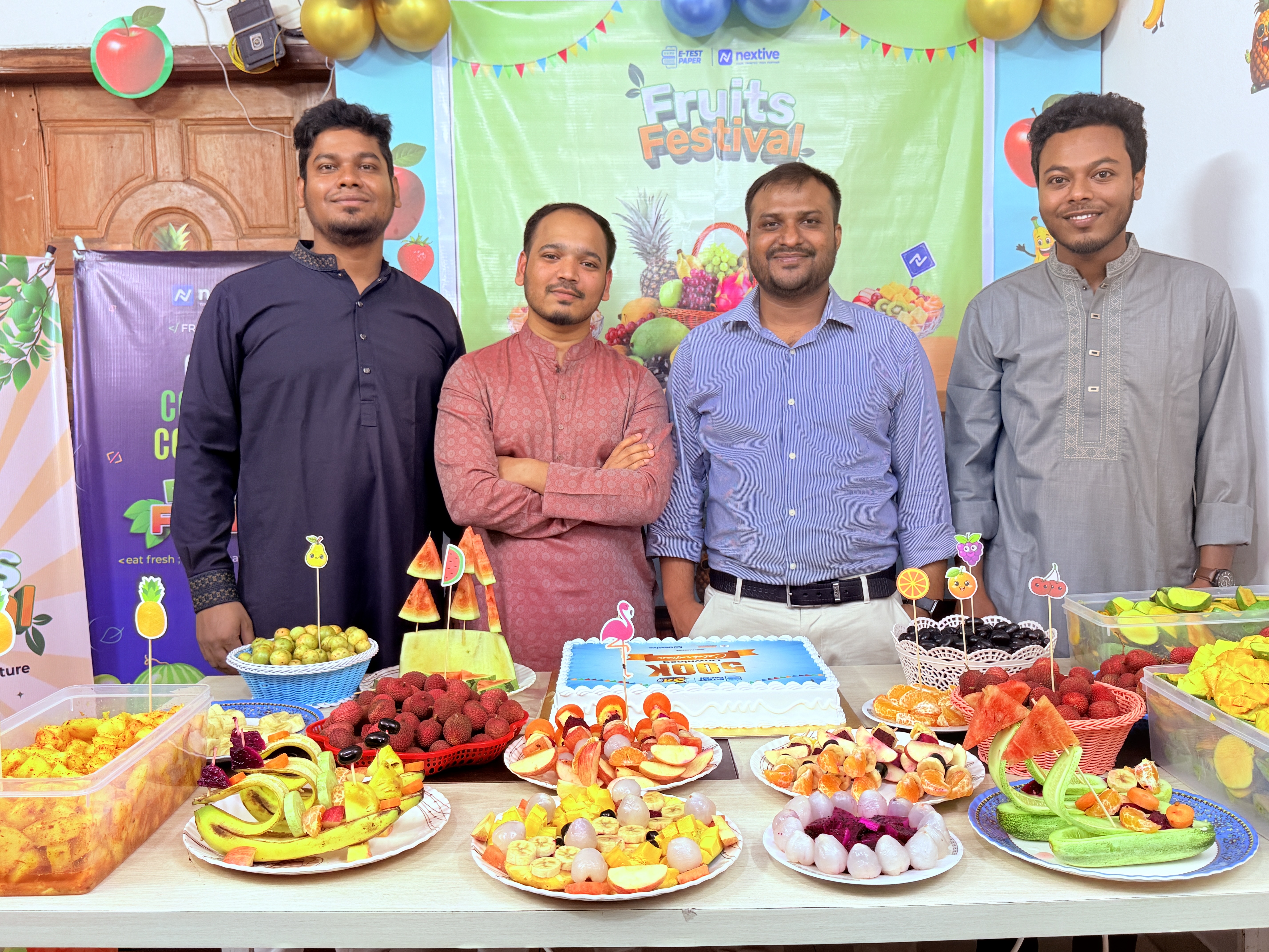 Team posing at Fruits Festival with banner